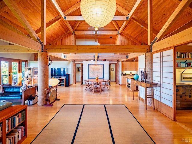 dining area with light wood finished floors, wood ceiling, and beamed ceiling