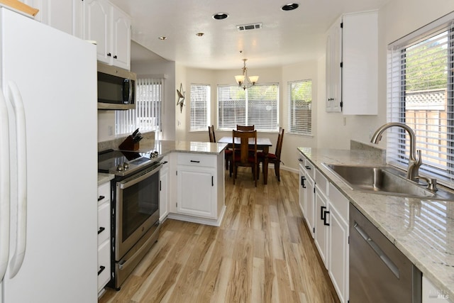 kitchen featuring an inviting chandelier, visible vents, appliances with stainless steel finishes, a sink, and light wood finished floors