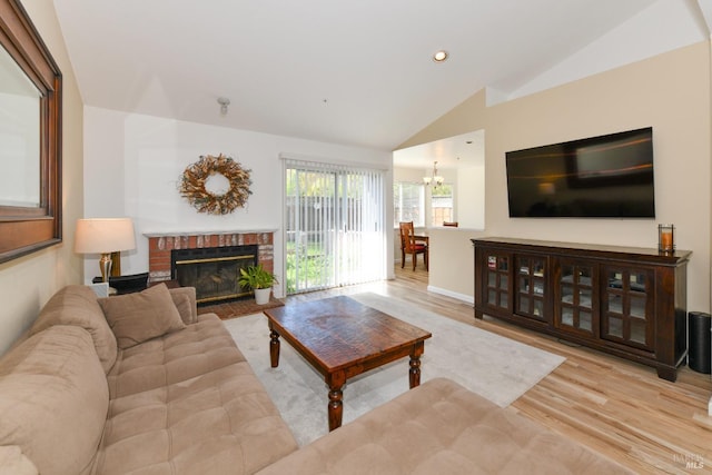 living room featuring a notable chandelier, a brick fireplace, recessed lighting, wood finished floors, and vaulted ceiling