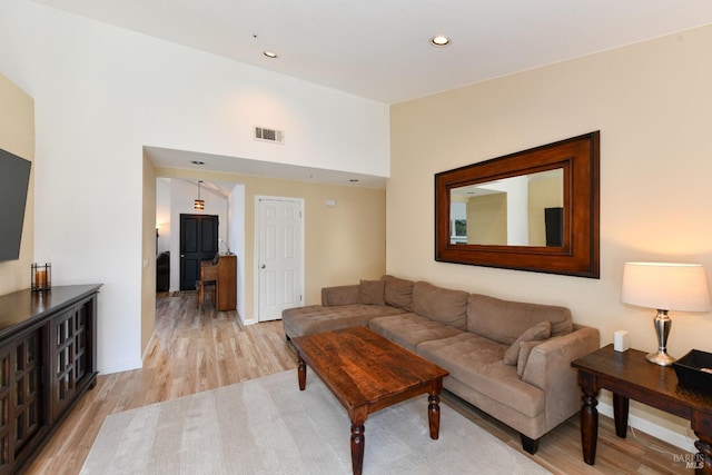 living area featuring visible vents, baseboards, recessed lighting, and light wood-style floors