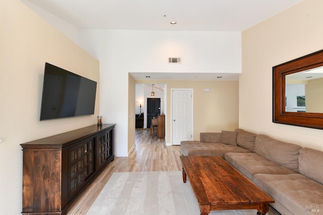 living area featuring visible vents, baseboards, light wood finished floors, and recessed lighting