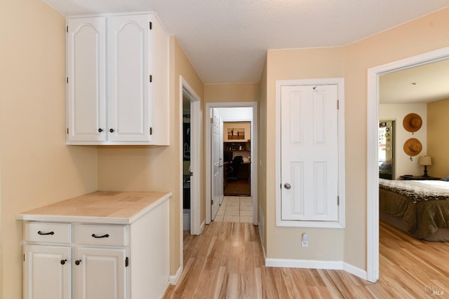hallway with light wood finished floors and baseboards