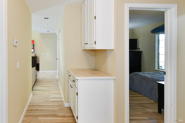 hall with light wood-type flooring, baseboards, and recessed lighting