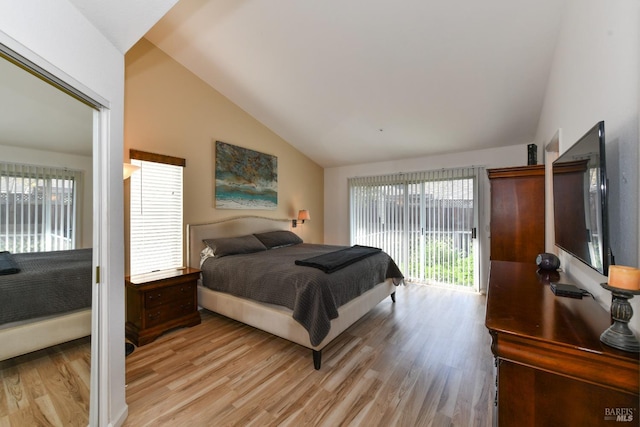 bedroom featuring access to exterior, light wood finished floors, multiple windows, and vaulted ceiling