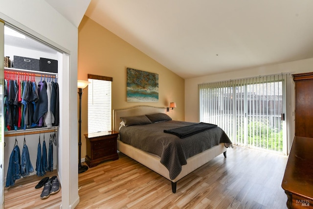 bedroom with access to outside, a closet, light wood finished floors, and vaulted ceiling