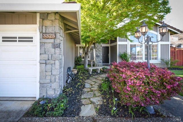view of exterior entry with stone siding and a garage