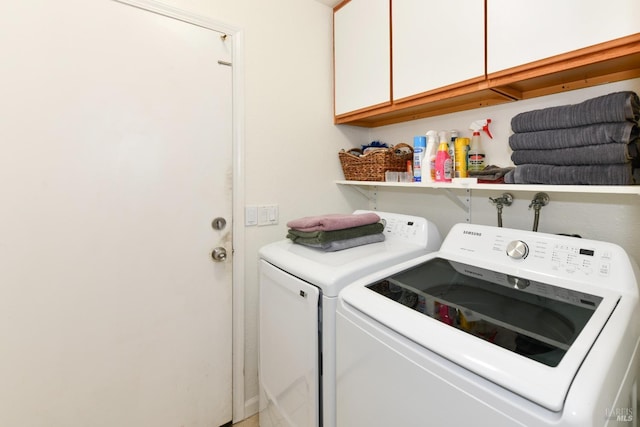 washroom with cabinet space and washing machine and dryer