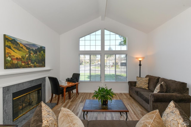 living room featuring beamed ceiling, plenty of natural light, and wood finished floors