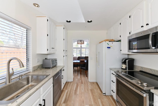 kitchen featuring white cabinets, recessed lighting, a sink, stainless steel appliances, and light wood finished floors