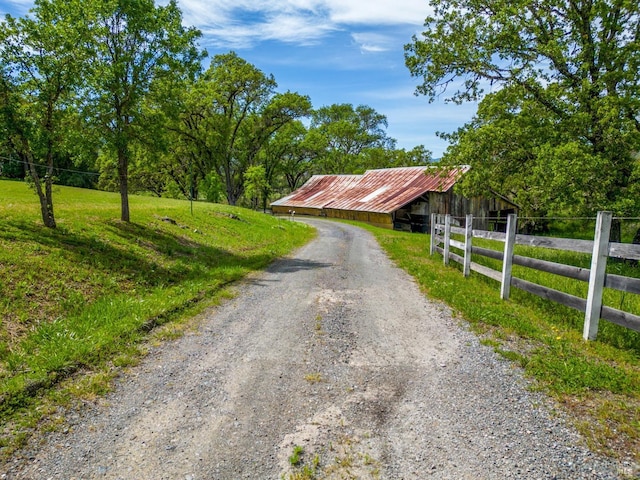 view of street featuring an outbuilding and dirt driveway