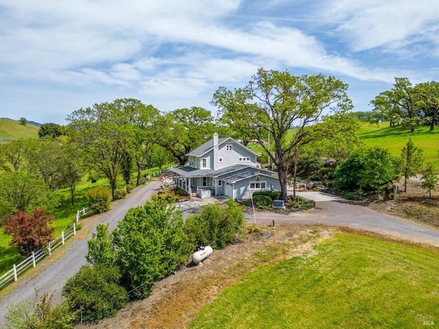 view of front of property with a chimney, fence, and dirt driveway