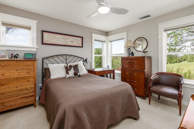 bedroom featuring visible vents, light colored carpet, and ceiling fan