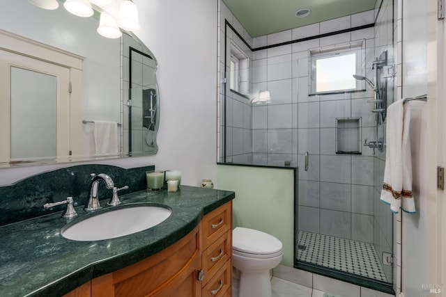 bathroom featuring toilet, a shower stall, and vanity