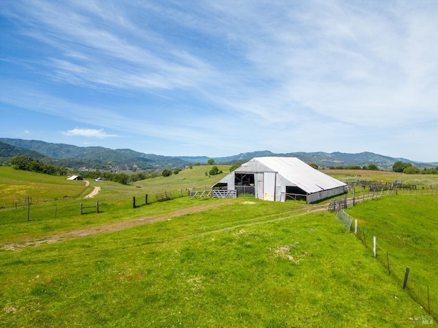 view of yard with a mountain view, an outdoor structure, and a rural view