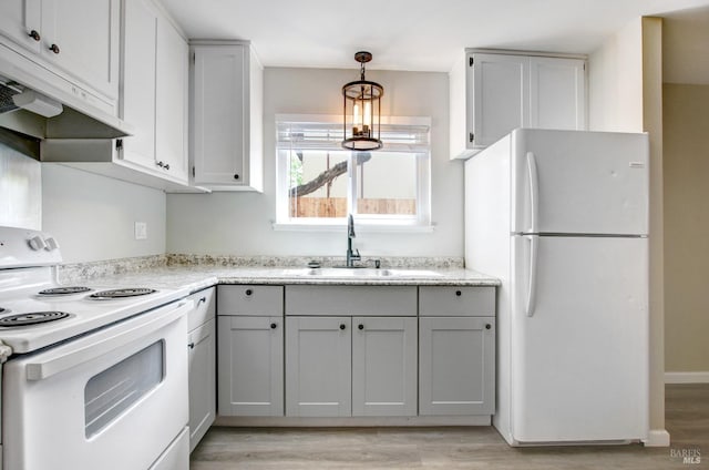 kitchen featuring decorative light fixtures, a sink, white appliances, under cabinet range hood, and light wood finished floors