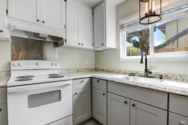 kitchen with under cabinet range hood, electric stove, a sink, and gray cabinets