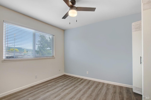 unfurnished room with baseboards, a ceiling fan, and wood finished floors