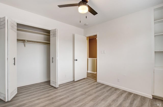 unfurnished bedroom with a closet, baseboards, light wood-type flooring, and ceiling fan
