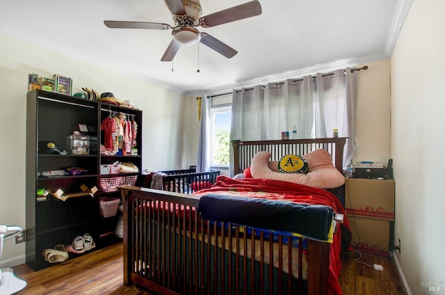 bedroom featuring ornamental molding, baseboards, ceiling fan, and wood finished floors