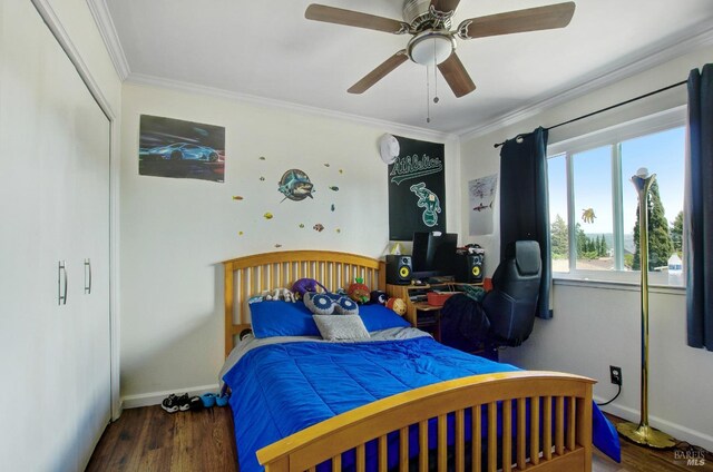 bedroom featuring ornamental molding, baseboards, ceiling fan, and wood finished floors