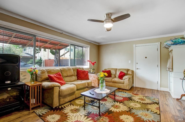 living room with crown molding, ceiling fan, wood finished floors, and baseboards