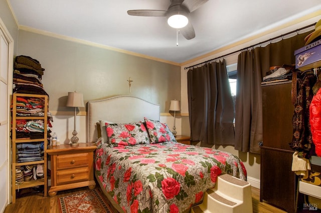 bedroom with crown molding, a ceiling fan, and wood finished floors