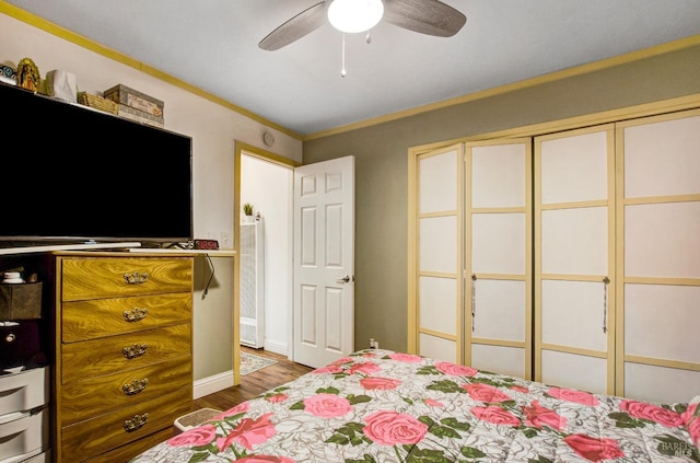 bedroom with crown molding, ceiling fan, wood finished floors, and baseboards