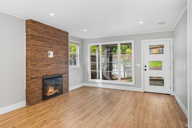 unfurnished living room with baseboards, crown molding, and wood finished floors