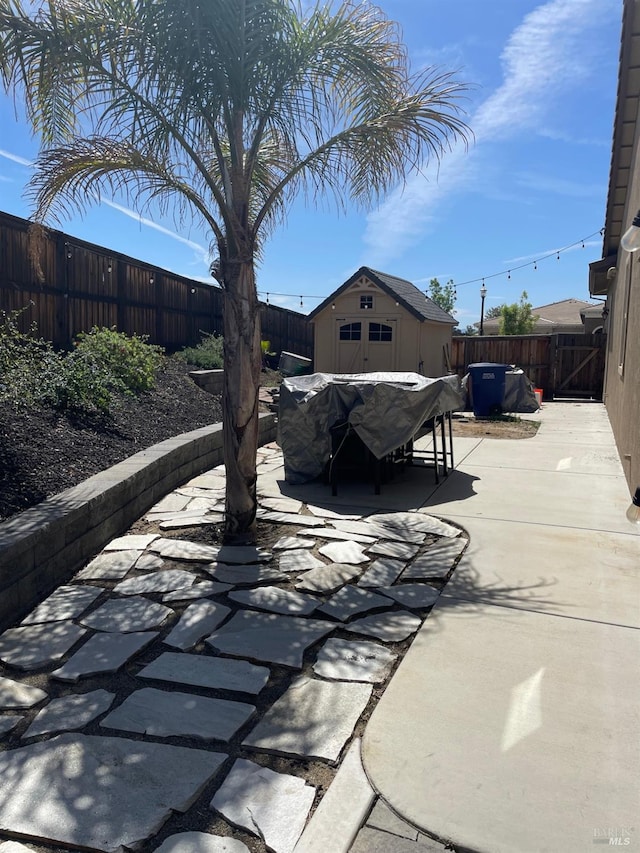 view of patio / terrace with a fenced backyard and an outdoor structure