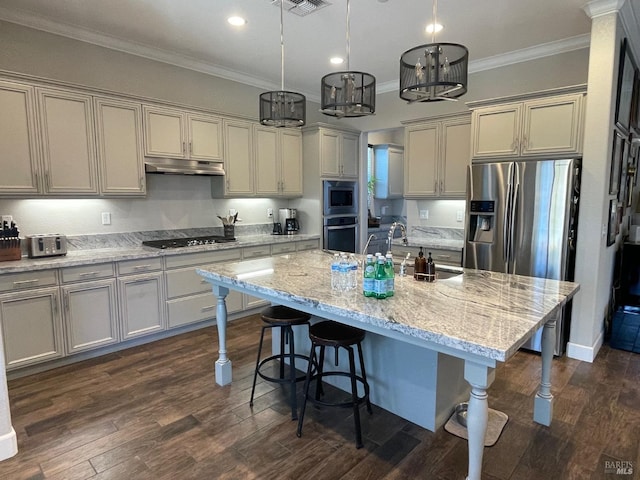 kitchen featuring stainless steel appliances, a breakfast bar area, under cabinet range hood, and ornamental molding