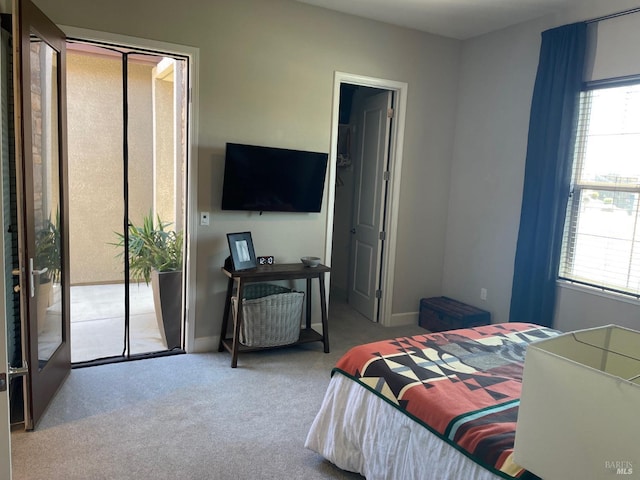 bedroom featuring access to exterior, multiple windows, and carpet floors