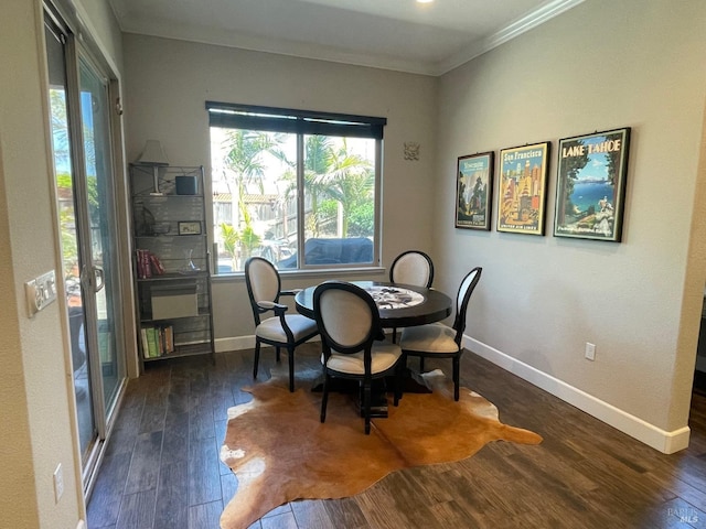 dining area with crown molding, baseboards, and wood finished floors
