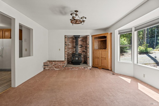 26228 Otter Dr, Willits, CA 95490 - unfurnished living room featuring a wood stove, a notable chandelier, and carpet