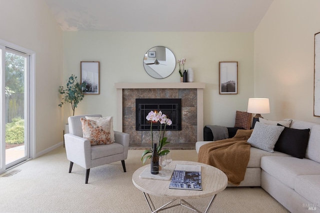 living room with a fireplace, carpet, visible vents, and baseboards