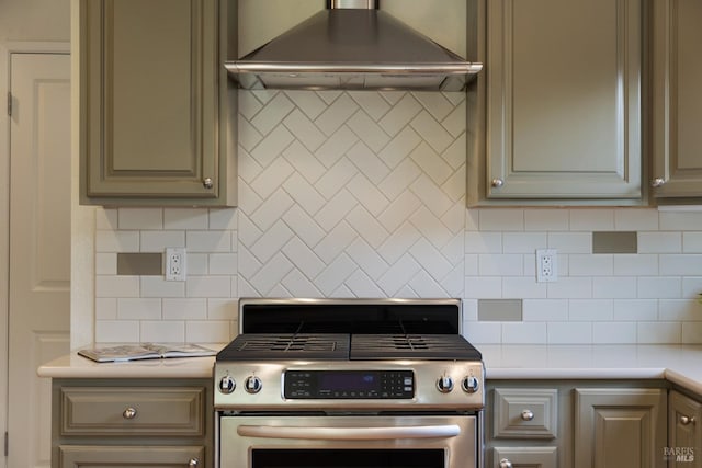 kitchen with light countertops, decorative backsplash, stainless steel gas range, and range hood
