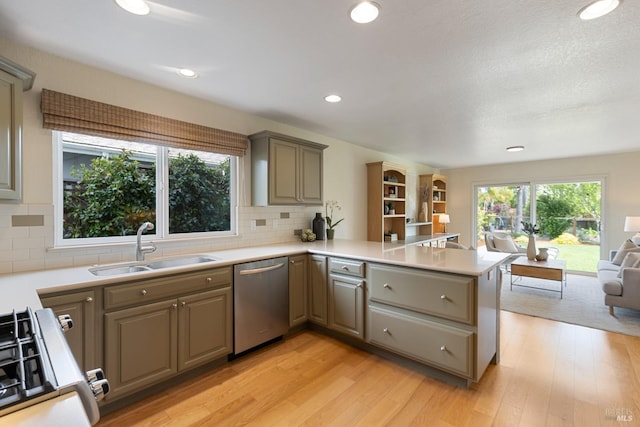 kitchen with gray cabinetry, dishwasher, gas stove, and a sink