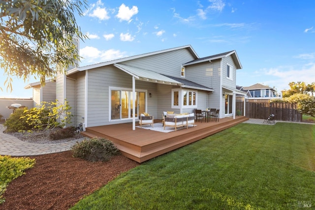 back of property featuring outdoor lounge area, a yard, a deck, and fence