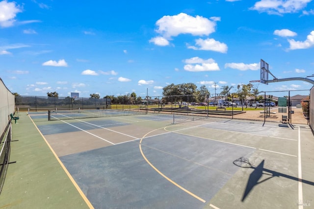 view of basketball court featuring community basketball court, fence, and a tennis court