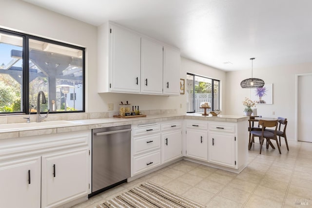 kitchen with light countertops, dishwasher, a sink, and white cabinets