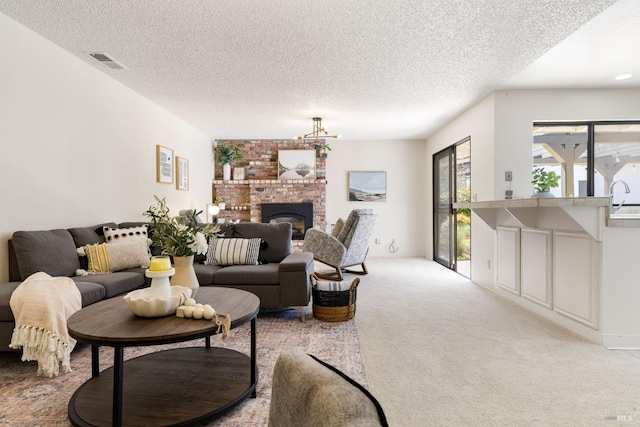 living room featuring a textured ceiling, a brick fireplace, carpet, and visible vents