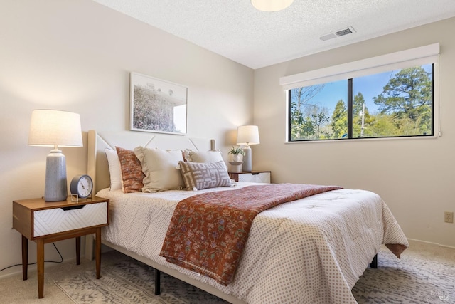 bedroom featuring carpet flooring, visible vents, baseboards, and a textured ceiling
