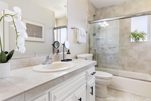 full bathroom with visible vents, toilet, vanity, shower / bath combination with glass door, and tile patterned flooring