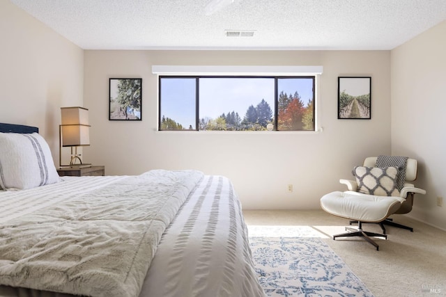 bedroom featuring a textured ceiling, carpet, and visible vents
