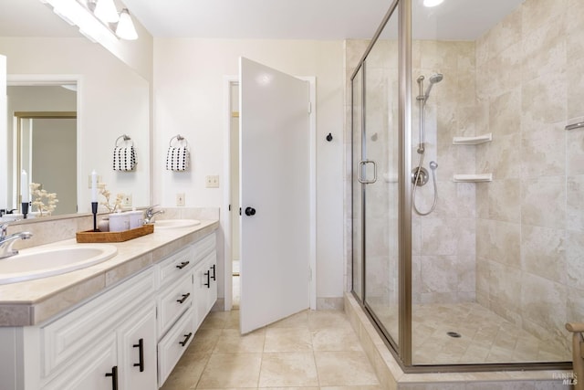 bathroom featuring a shower stall, tile patterned floors, double vanity, and a sink