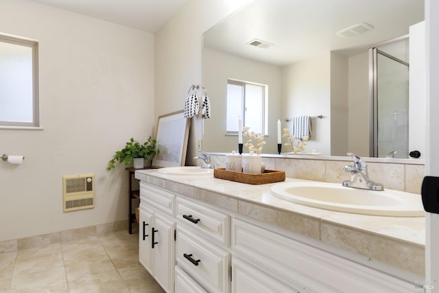 bathroom featuring visible vents, a stall shower, a sink, and heating unit