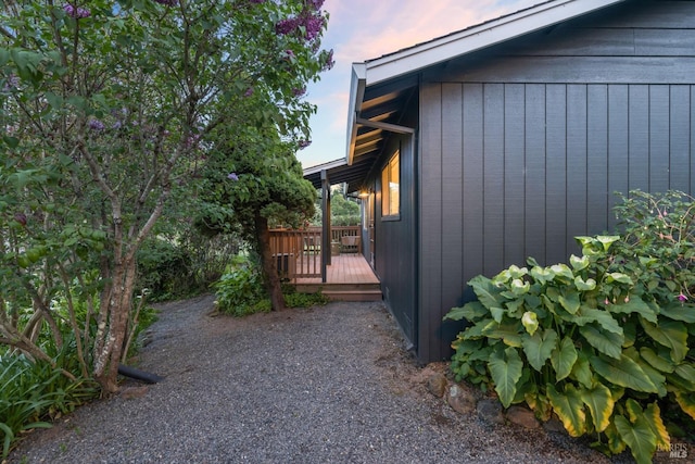 property exterior at dusk featuring a wooden deck