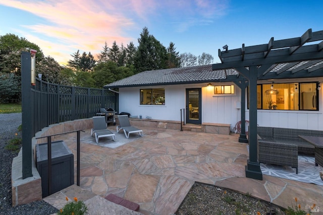 back of property at dusk featuring a pergola, a patio, fence, and a tile roof