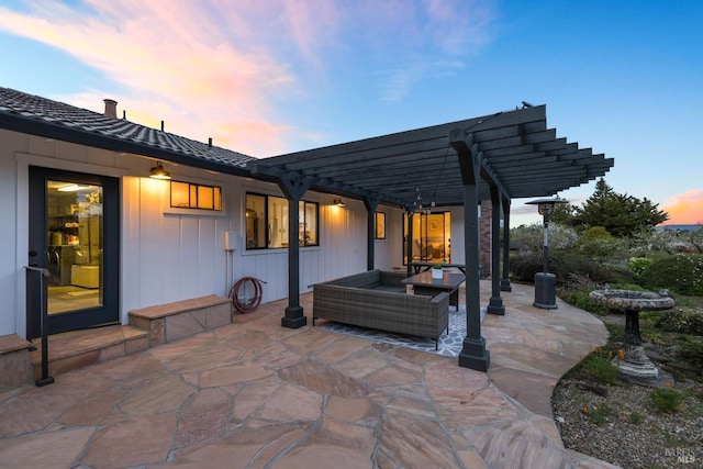 patio terrace at dusk with a pergola and outdoor lounge area