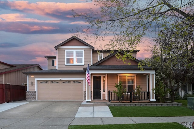 craftsman-style house with a yard, a porch, a garage, fence, and concrete driveway