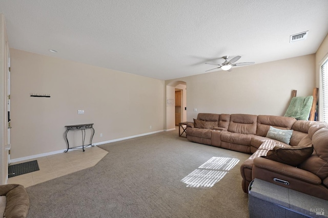living area with baseboards, visible vents, ceiling fan, arched walkways, and carpet